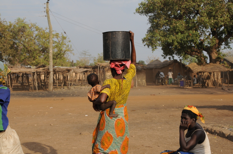 Baby gets a ride while mom works carrying water. Notice how there is no obesity here... everyone just works :-) No need to go to the gym.